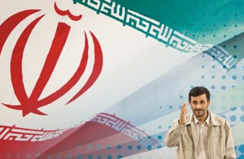 Ahmadinejad behind massive Iranian flag 370 (photo credit: REUTERS/Raheb Homavandi)