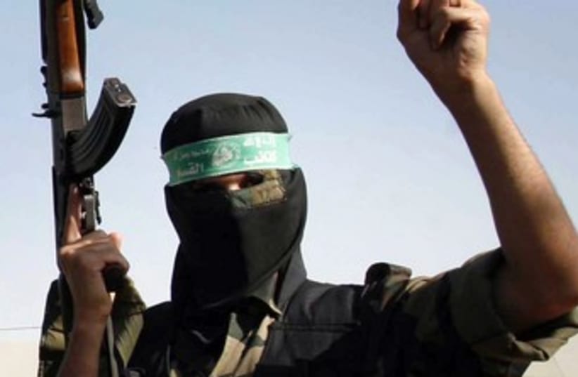 A masked Hamas man holds a gun 370 (R) (photo credit: Ibraheem Abu Mustafa / Reuters)