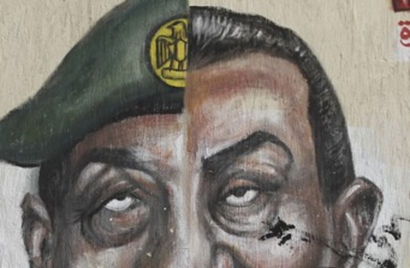 Spraypainted faces of Mubarak, Tantawi 370 (photo credit: REUTERS/Amr Dalsh)