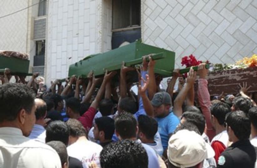Syrians carry coffins of protesters 370 (R) (photo credit: REUTERS)