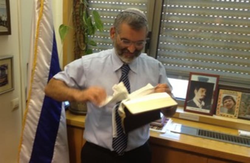 MK Ben-Ari tearing up a New Testament 370 (photo credit: Itamar Ben-Gvir)