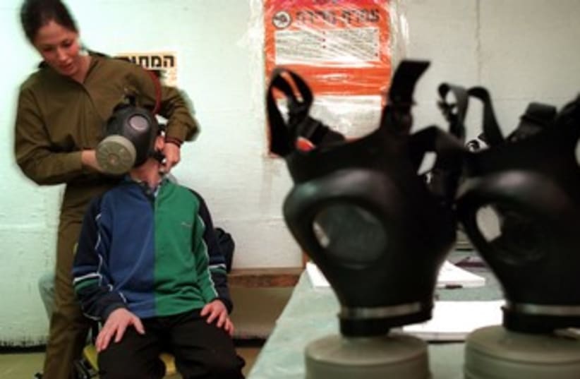 IDF soldier fits child with gas mask 370 (photo credit:  	 REUTERS/David Silverman)