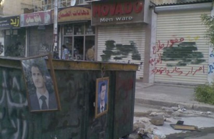 Pictures of Assad hang from garbage containers in Aleppo 370 (photo credit: REUTERS)