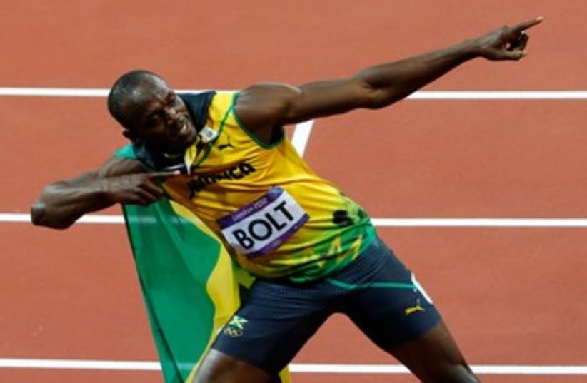 Usain Bolt after winning the 100m 370 (R) (photo credit: REUTERS)