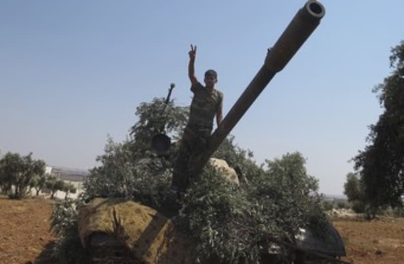 Syrian rebel with captured tank 370 (photo credit: REUTERS)