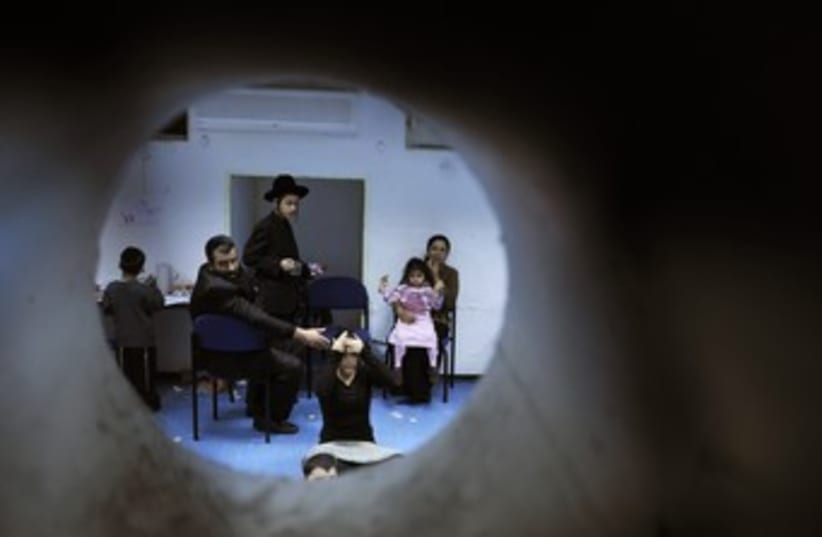 Israelis in Bomb Shelter (photo credit: Amir Cohen / Reuters)