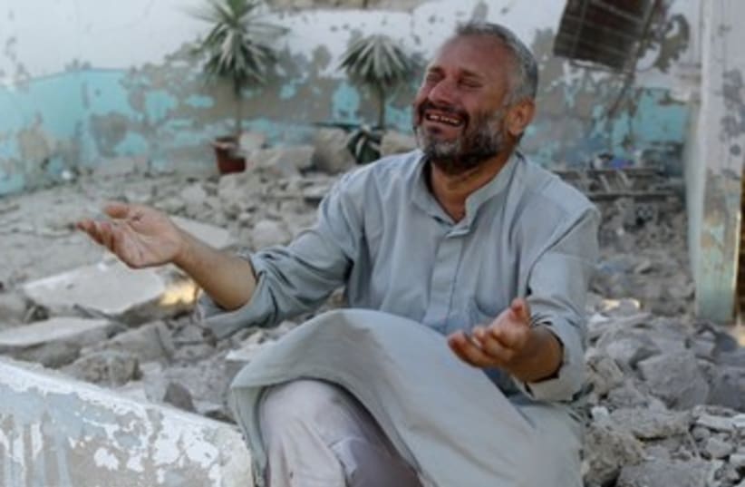 Man mourns after Syrian jets strike northern town 370 (photo credit: reuters)