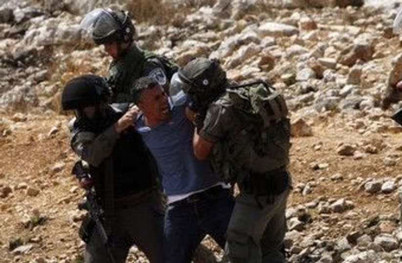 Security forces detain a Palestinian in Nabi Saleh 370 (R) (photo credit: Mohamad Torokman / Reuters)
