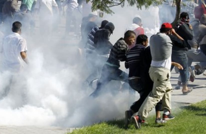 Protesters run for cover outside US Embassy in Tunis 390 (R) (photo credit: Zoubeir Souissi / Reuters)