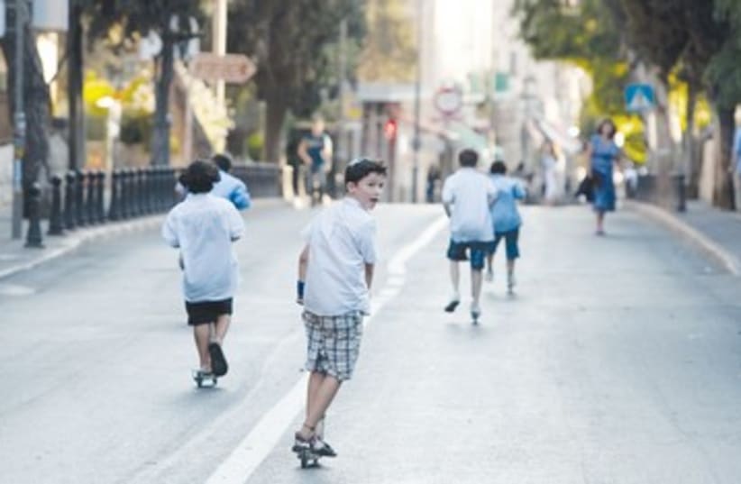 Kids ride scooters on Yom Kippur 390 (photo credit: Darren Whiteside/Reuters)