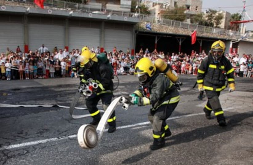 Firefighters unravel hose (photo credit: Marc Israel Sellem)