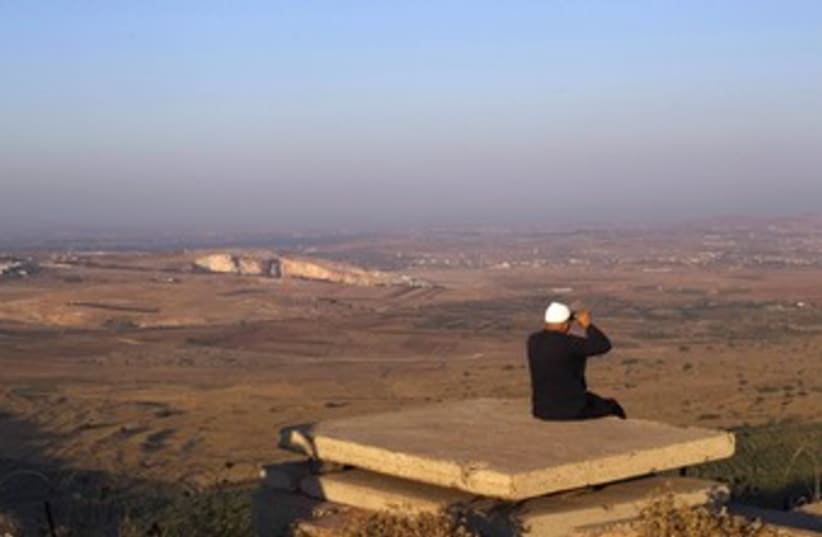 Druse man looks out at Syria from the Golan 370 (R) (photo credit: Ronen Zvulun / Reuters)