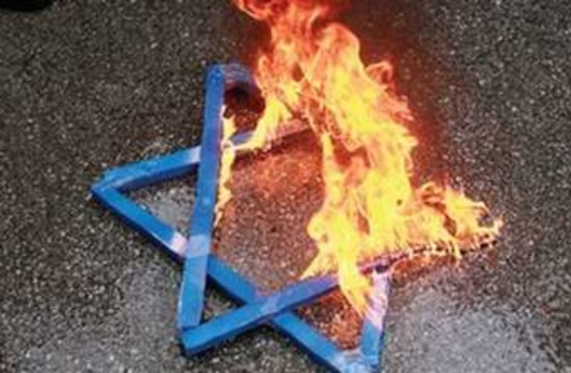 Burning Jewish star (photo credit: UMIT BEKTAS/REUTERS)