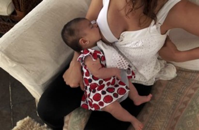 Mother breastfeeds her 2 month-old daughter 370 (photo credit: Pilar Olivares / Reuters)