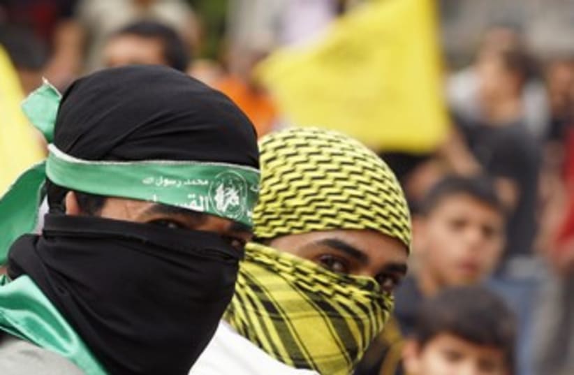 Palestinians wearing Hamas, Fatah masks 370 (photo credit: REUTERS/Ismail Zaydah)