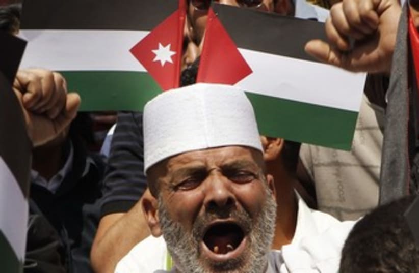 Man yelling in front of Palestinian, Jordanian flags 370 (photo credit: REUTERS/Ali Jarekji)