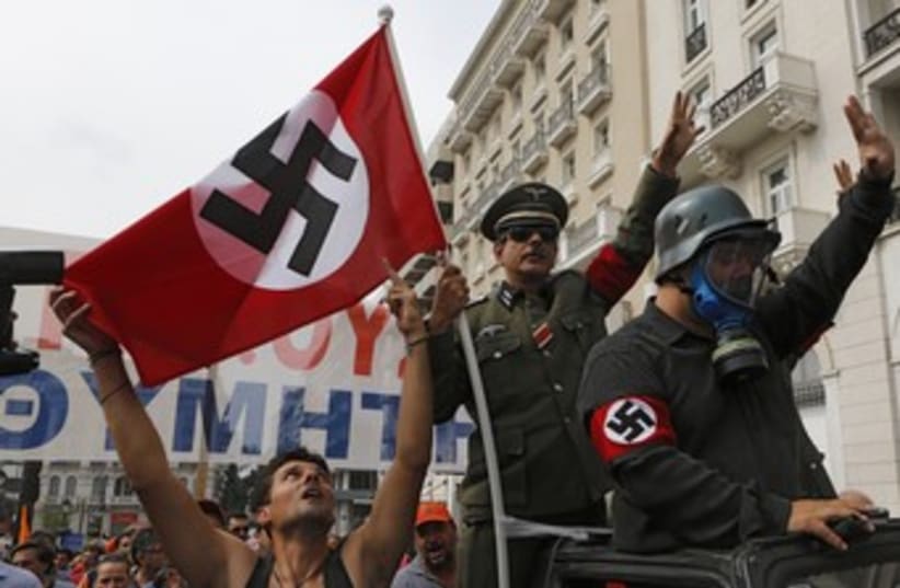 Greeks wave swastikas to greet Merkel 370 (photo credit: REUTERS/Yannis Behrakis)