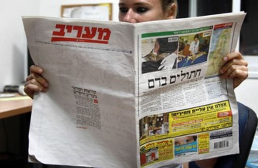 Woman reads Ma'ariv 370 (photo credit: Marc Israel Sellem/The Jerusalem Post)