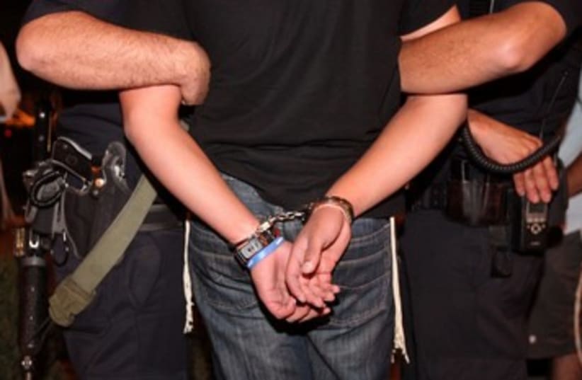 Handcuffs arrest police crime illustrative 390 (photo credit: Marc Israel Sellem/The Jerusalem Post)