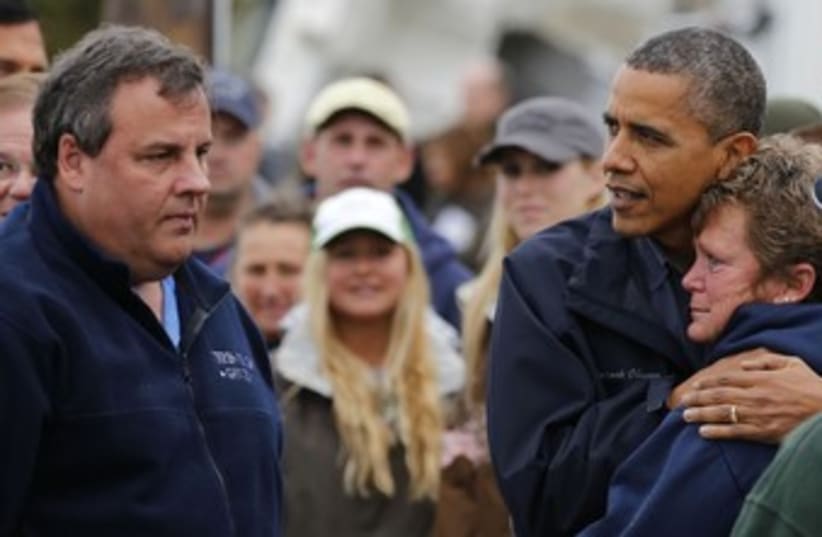 Obama and Chris Christie comfort a storm victim 370 (R) (photo credit: Larry Downing / Reuters)