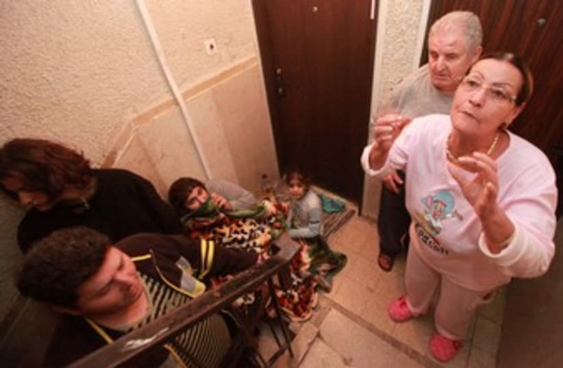 Beersheba residents take shelter in a stairwell 370 (photo credit: Marc Israel Sellem / The Jerusalem Post)