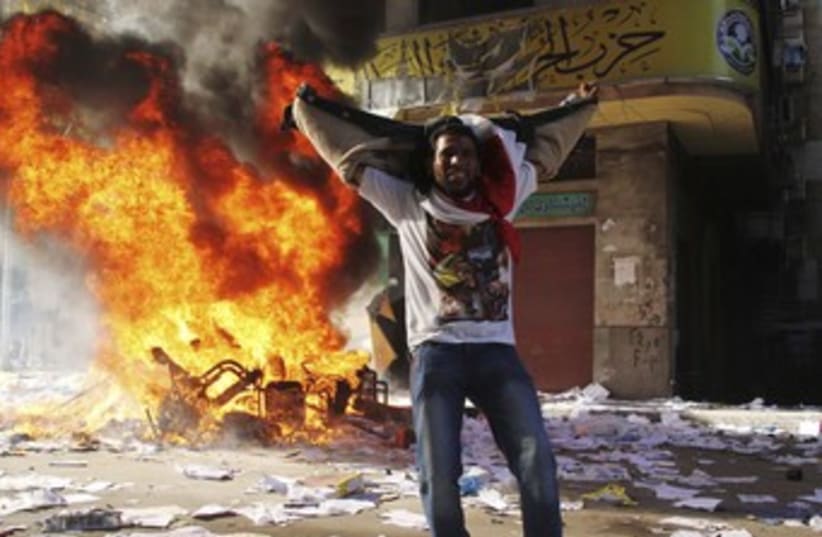 Protester cheers as Egypt's Brotherhood office ransacked 370 (photo credit: REUTERS)