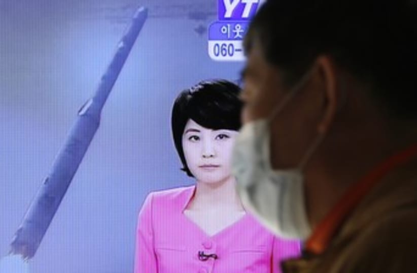 TV report on North Korean rocket launch 370 (R) (photo credit: Lee Jae Won / Reuters)