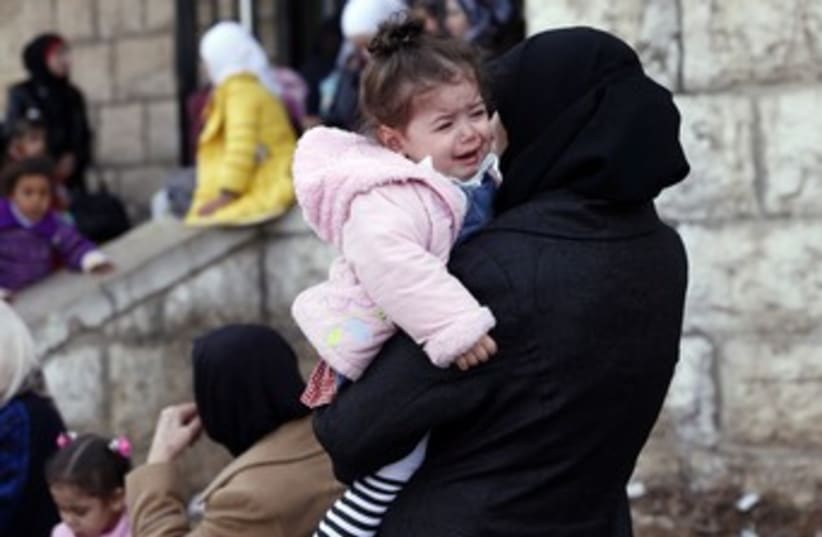 Palestinians in Syria, woman with child 370 (photo credit: REUTERS/Jamal Saidi)