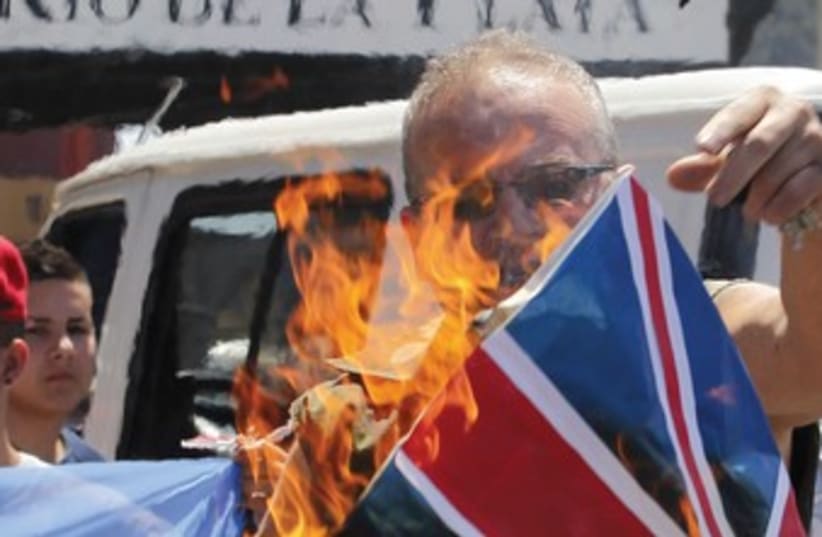 A protester burns UK flag in Argentina 370R (photo credit: Enrique Marcarian/Reuters)