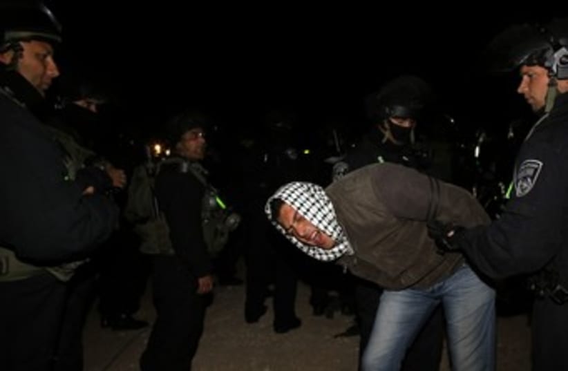 Police detain a Palestinian man at E1 outpost 370 R (photo credit: Ammar Awad / Reuters)