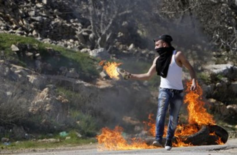 Palestinian throwing a molotov cocktail 370 (photo credit: REUTERS/Mohamad Torokman)