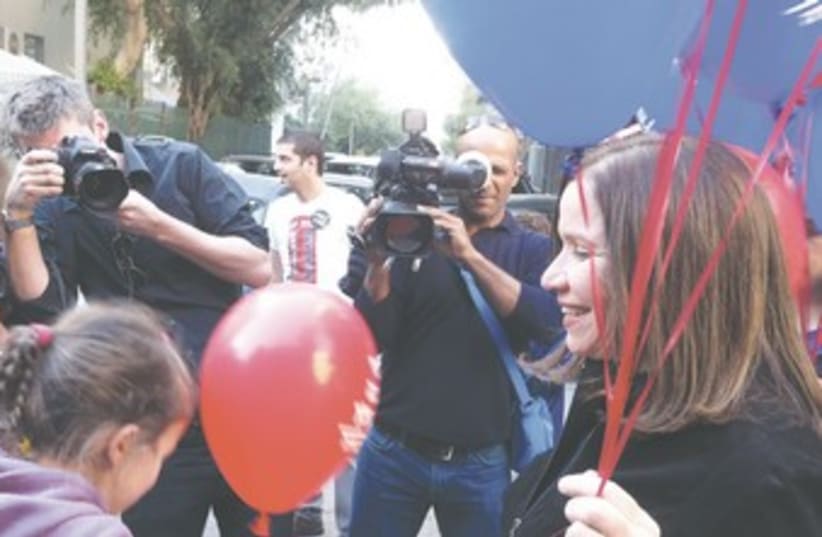 Yacimovich gives out balloons to preschool kids oin TA 370 (photo credit: LAHAV HARKOV)