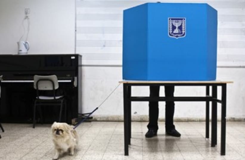 A Tel Aviv man votes with his dog 370 (photo credit: Nir Elias/Reuters)