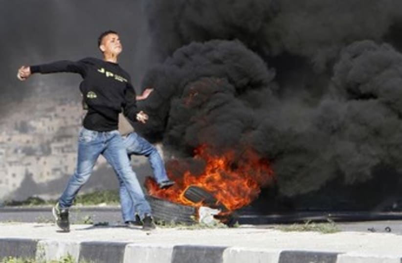 Palestinian protest flame HawaraCheckpoint 370 (photo credit: Abed Omar Qusini)