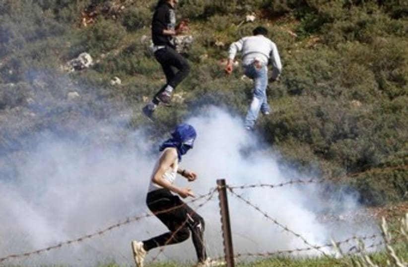 Palestinians flee tear gas 370 (photo credit: REUTERS)