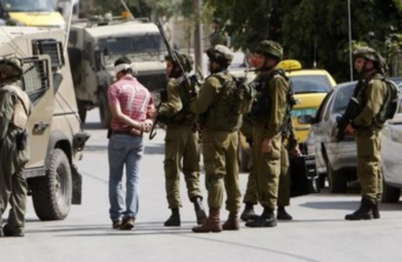 IDF soldiers arrest Palestinian 370 (photo credit: REUTERS/Mohamad Torokman)