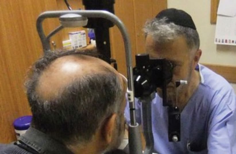 Eye doctor examines patient 370 (photo credit: Judy Siegel-Itzkovich)