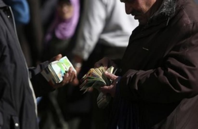 Palestinian money changers 370 (photo credit: REUTERS/Mohamad Torokman)