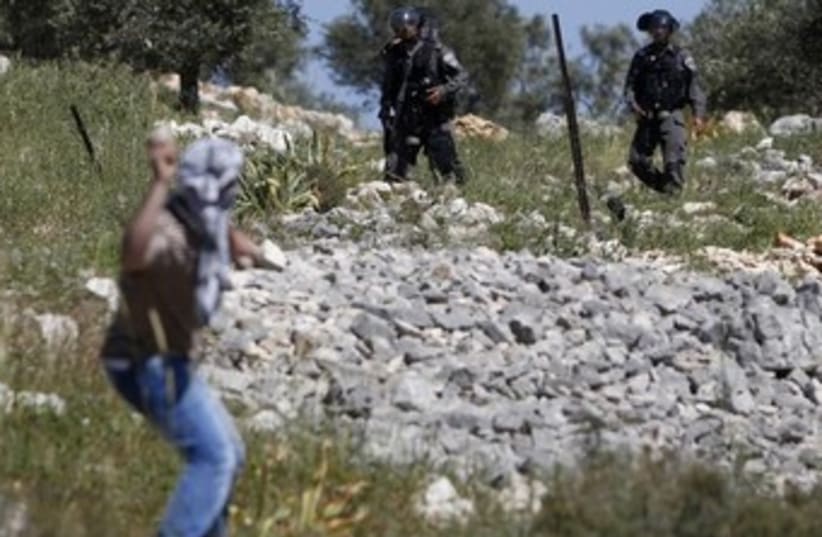 Palestinian throwing stones at Israeli border police 370 (photo credit: REUTERS/Mohamad Torokman)