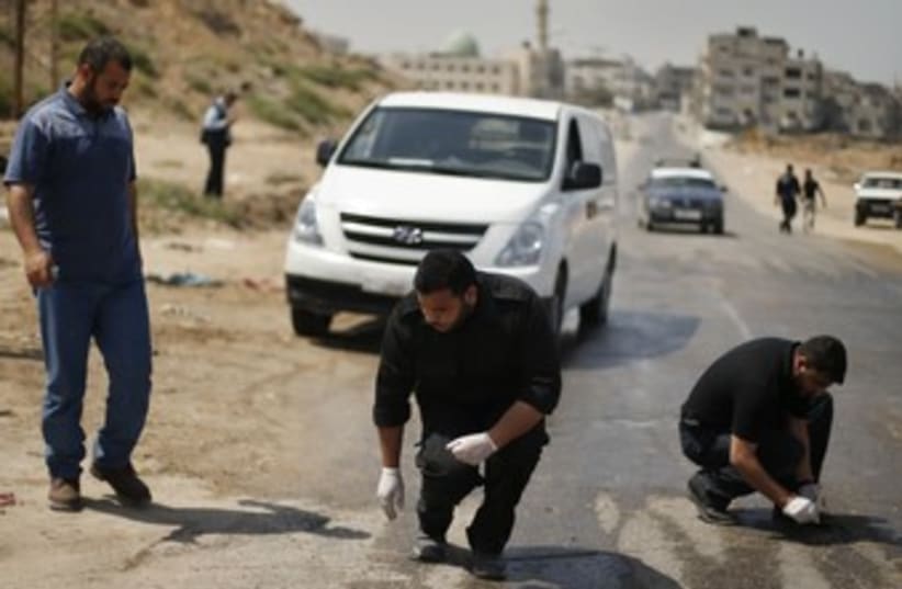 Palestinian police inspect scene after IAF strike, Gaza 370 (photo credit: REUTERS)