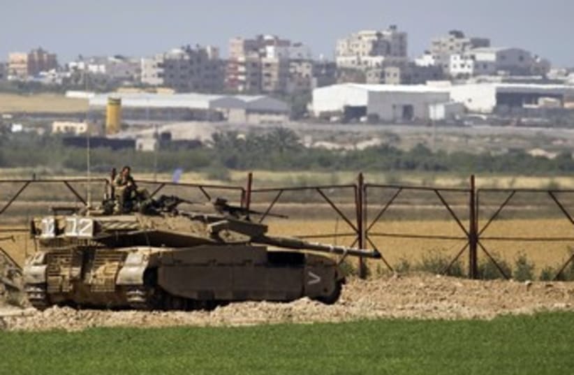 IDF soldier sits atop a tank just outside northern Gaza 370 (photo credit: REUTERS/Amir Cohen)