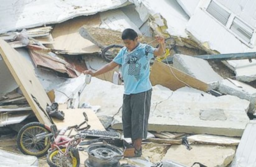 Beduin boy on rubble of demolished house 370 (photo credit: Wikimedia Commons)