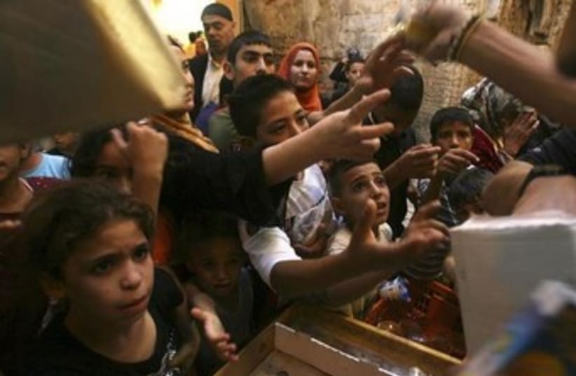 Palestinian kids clamor for food in Jerusalem 370 (photo credit: REUTERS/Ammar Awad)