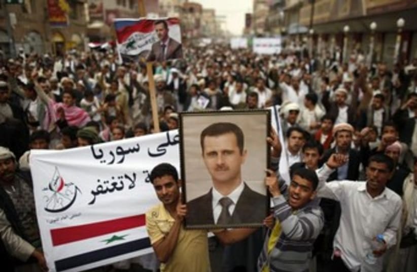 Syrian anti government protesters holding assad pic 370 (photo credit: REUTERS)