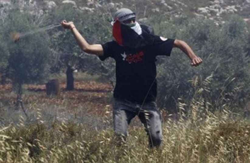 Palestinian uses slig to throw rocks 370 (photo credit: REUTERS/Mohamad Torokman)