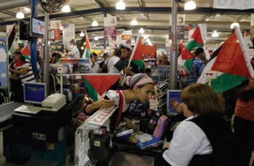 Palestinian protesters at supermarket in West Bank 370 (photo credit: REUTERS)