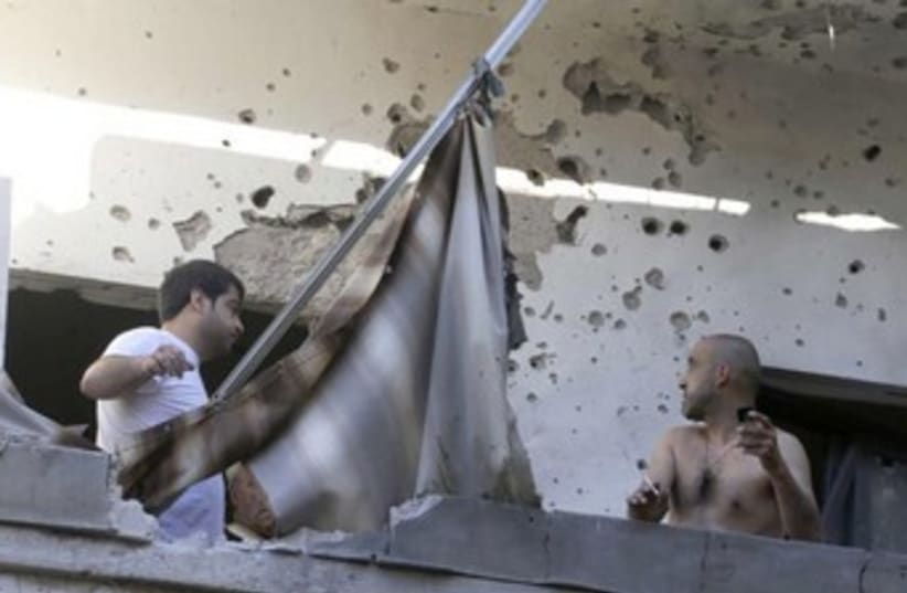 Two men at house damaged by rockets in Beirut 370 (photo credit: REUTERS/Mohammed Azakir)