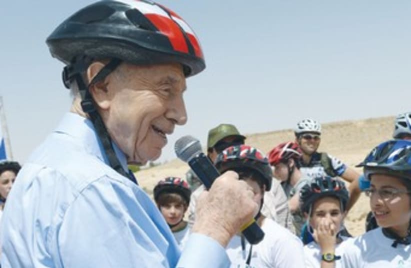 Peres in bike helmet with children370 (photo credit: Mark Neiman/GPO)