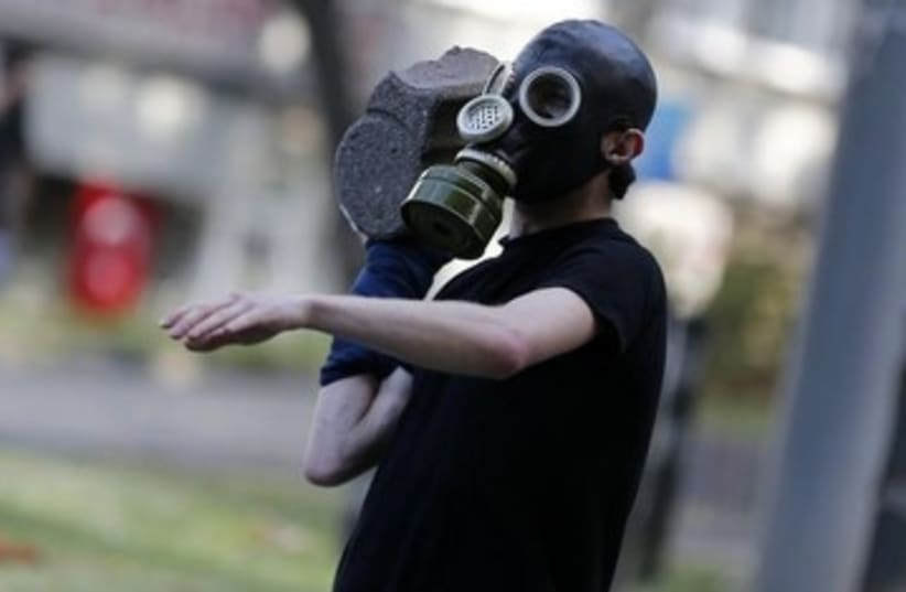 Rioter throws stone in Istanbul protest 390 (photo credit: REUTERS)