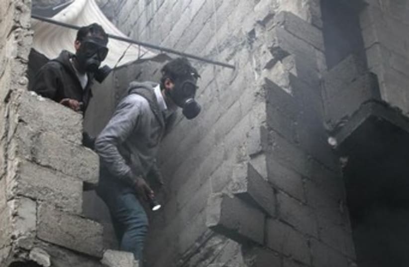 Syrian wear gas maks after shelling 370 (photo credit: REUTERS/Muzaffar Salman)
